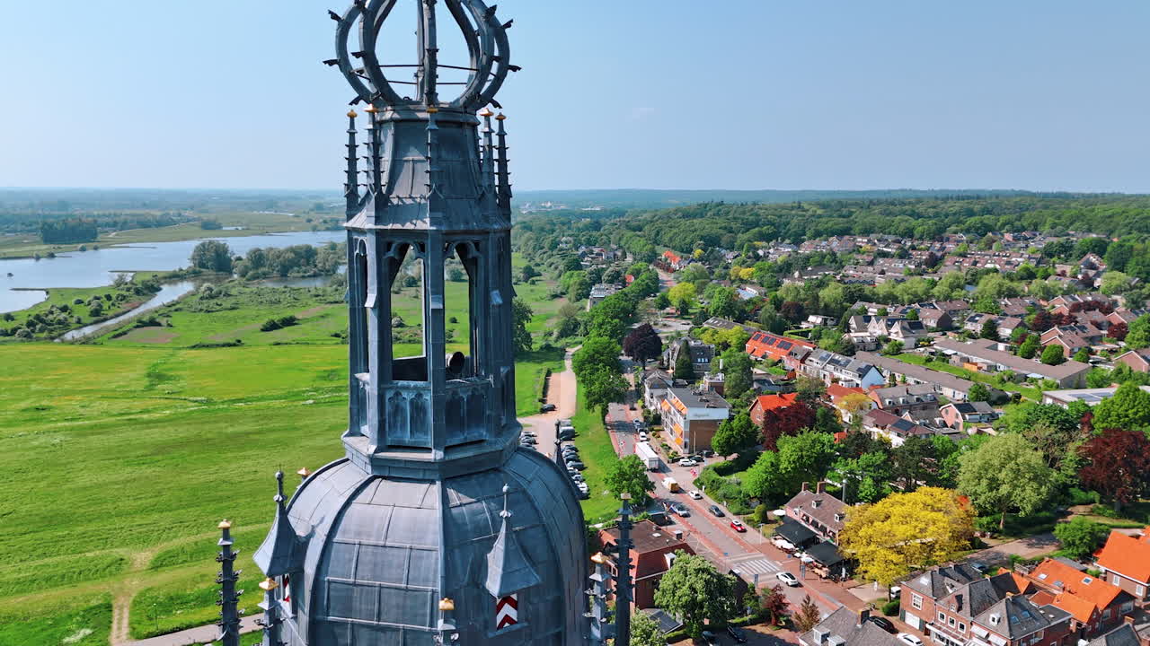Approaching the top of the Cunera Church in Rhenen, Province Utrecht, the Netherlands. Drone footage revealing view on the cottages, beautiful nature and river at backdrop.