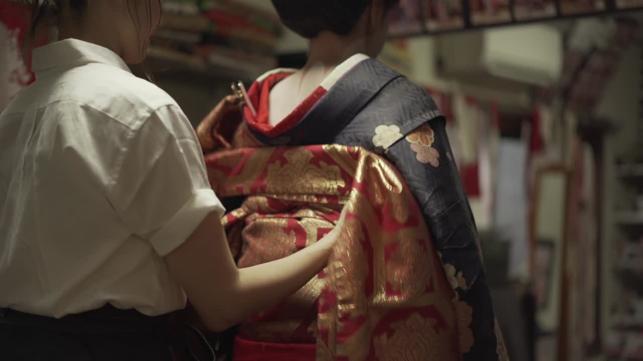 Maiko being dressed in a traditional Japanese Kimono in Kyoto Japan