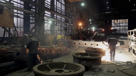 industrial welding and metal fabrication in a factory at night