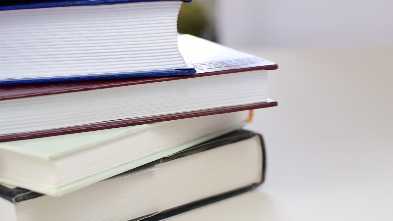 Desk with stack of study books. Textbooks for the student, university. Study from home. Distance education concept.