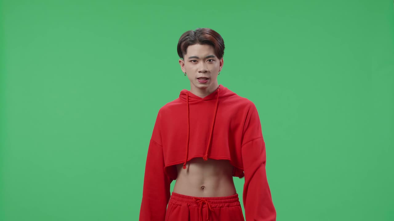 Angry Asian Transgender Male Scolding While Standing On Green Screen In The Studio