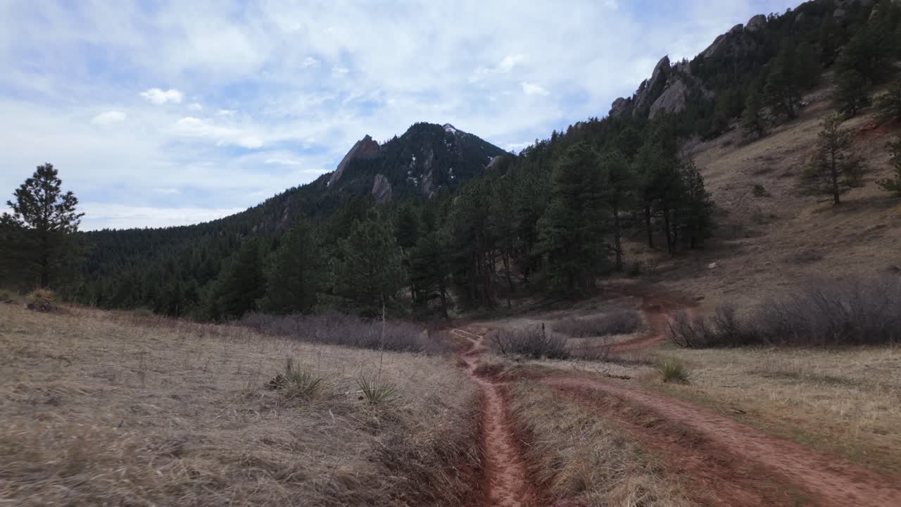 POV Of A Person Walking On The Narrow And Unpaved Trail To The Mountain.