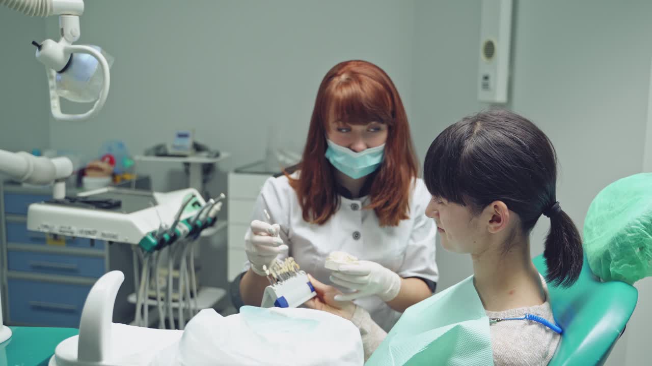 女性が歯科医で歯の診察を受けている。歯科クリニック。