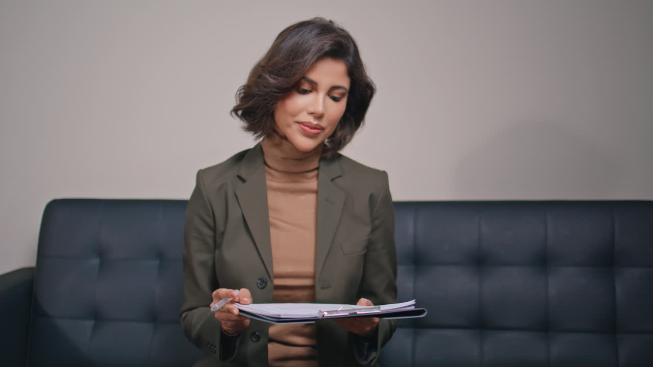 Professional woman analyzing papers on couch closeup. Lady reading documents