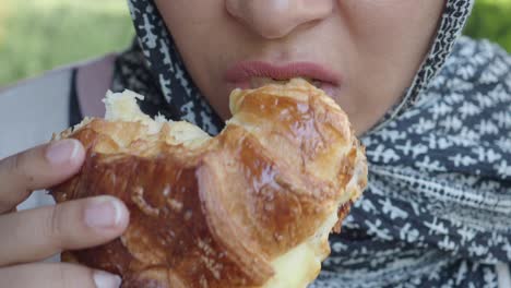 woman eating a croissant