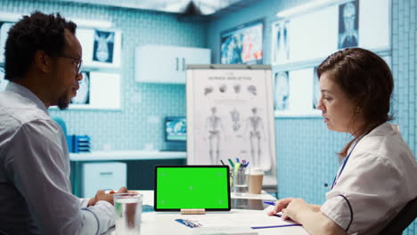 physician specialist looking at chroma key display in medical office