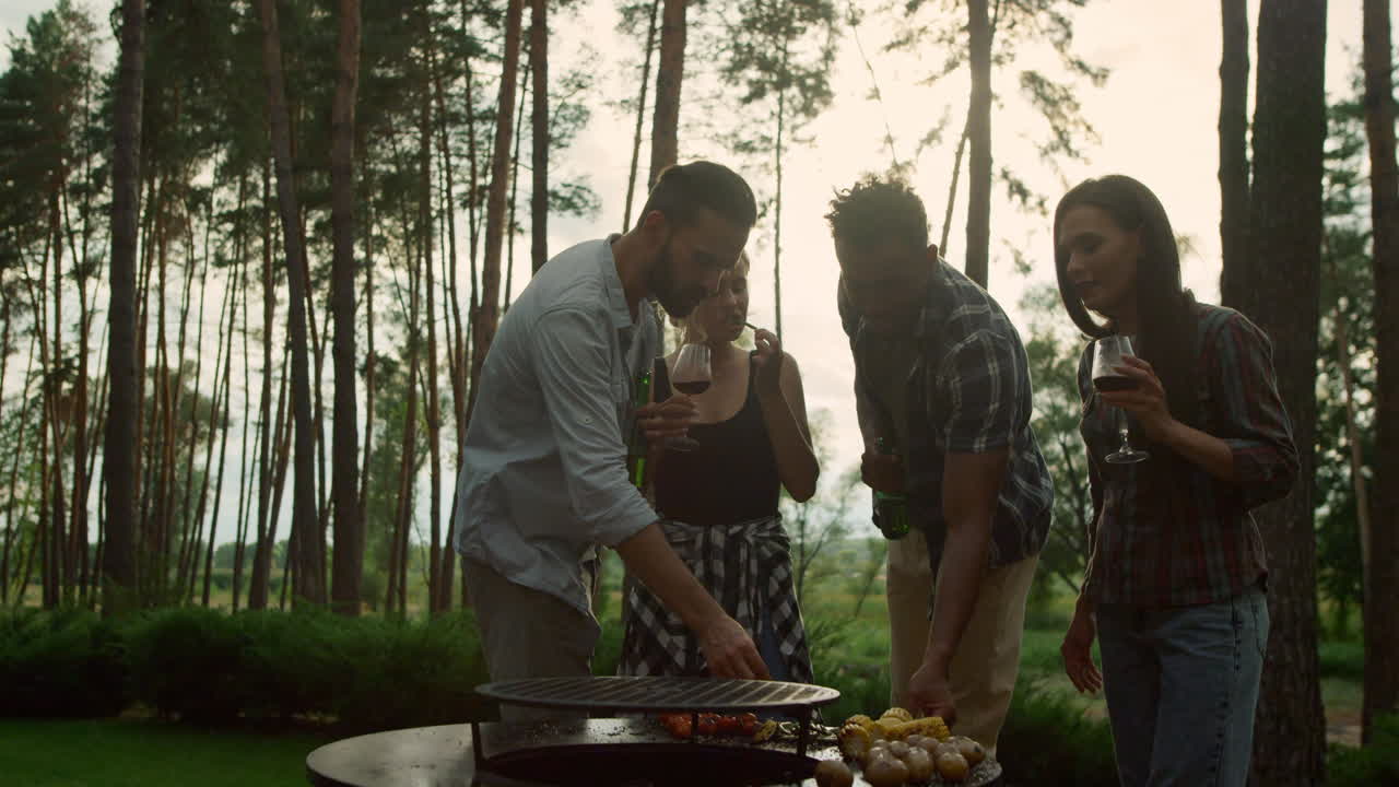 personas relajadas comiendo frijoles franceses en el bosque de verano. chicos probando verduras de barbacoa