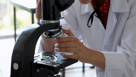 escolar experimentando con el microscopio en el laboratorio