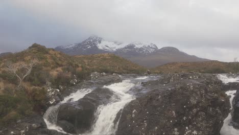 the view of the cuillins and a rushing stream in sligachan on an overcast day