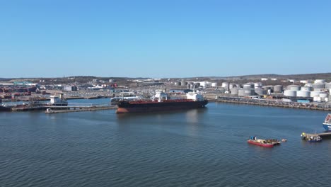 freighter ship dock on harbour with industrial container tanks in the background in gothenburg, sweden