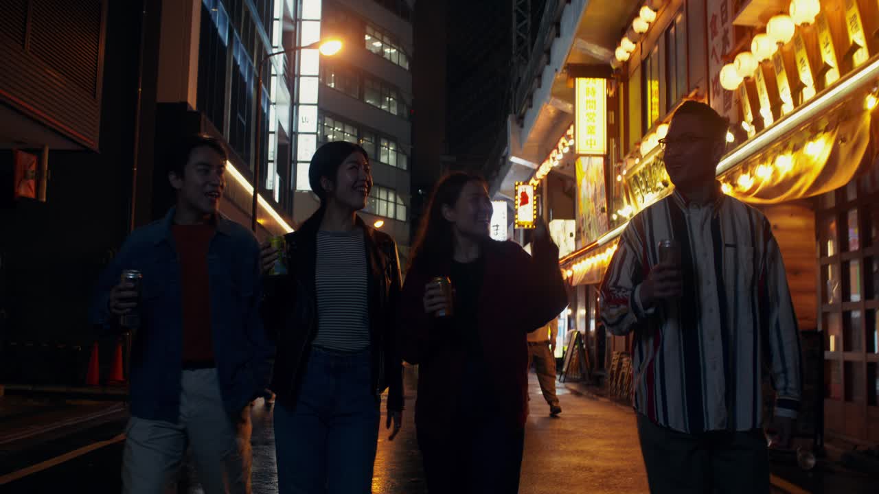 Group of friends walking in a city at night