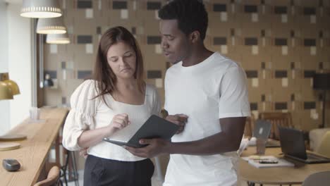 caucasian and african american coworkers discussing project