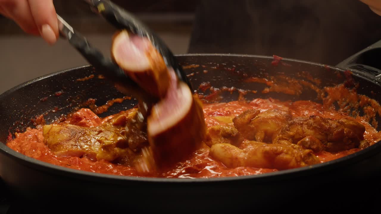 Chicken being cooked in a tomato sauce