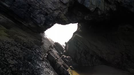 lot drona powietrznego przez dziurę w kształcie serca na klifie na plaży broughton na półwyspie gower w południowej walii