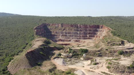 Flying-in-over-abandoned-mine-in-the-middle-of-a-lush-green-forest-during-a-hot-summers-day