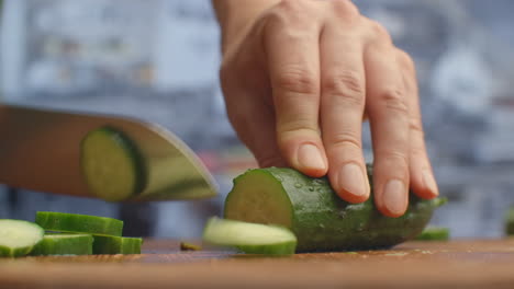 cut a knife on a wooden board closeup cucumbers in the kitchen. shred