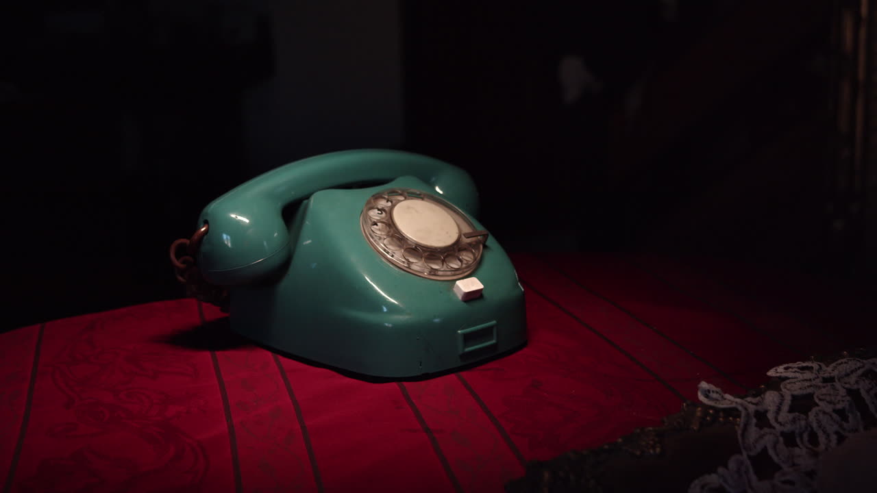 The camera is slowly moving away from the dial phone placed on the table in the retro interior