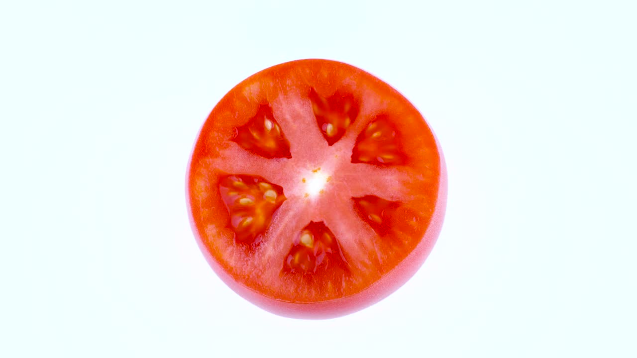 색 바탕에 고립 된 회전 테이블에서 회전하는 반 은 토마토의 절단 위의 면.