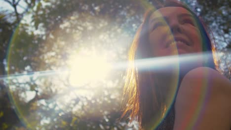 smiling middle aged hispanic woman looking over the shoulder, low angle with lens flare