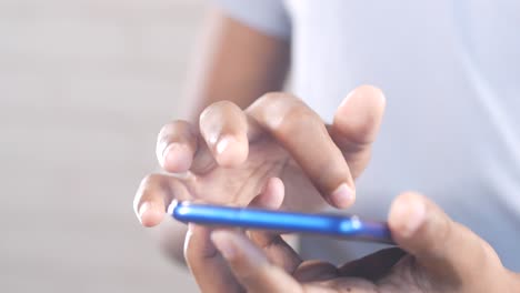 close up of young man hand using smart phone