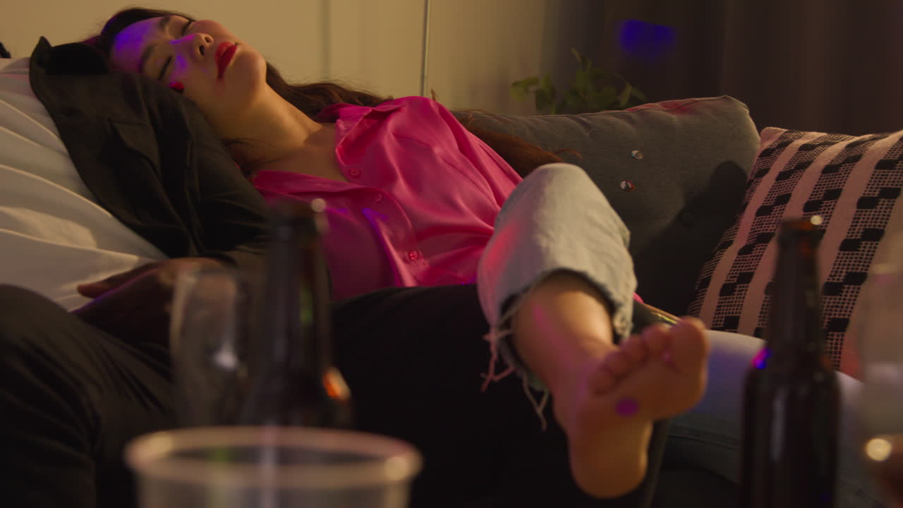 close up de una pareja acostada desmayada en el sofá después de beber alcohol en una fiesta de casa sufriendo de resaca