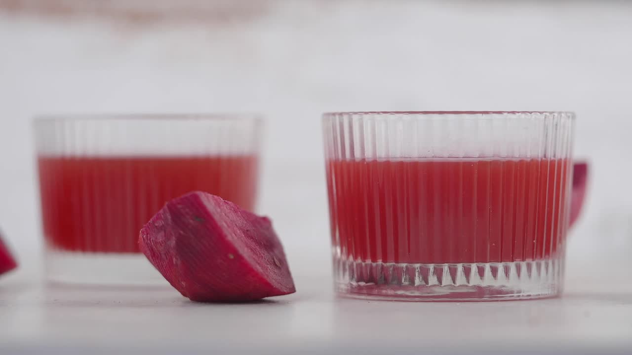 Mano che prende un bicchiere di succo rosso vivace