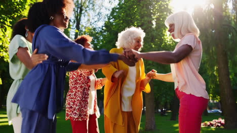 joyful multi-generational women dancing outdoors in a park