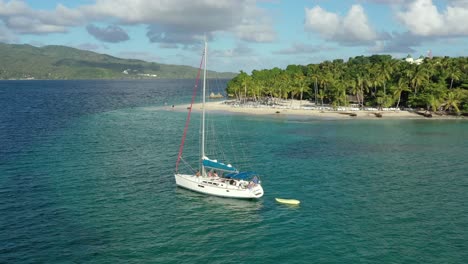 Antena-Dando-Vueltas-Alrededor-De-Un-Velero-Aislado-Amarrado-En-Aguas-Esmeralda-Cerca-De-Cayo-Levantado-En-República-Dominicana