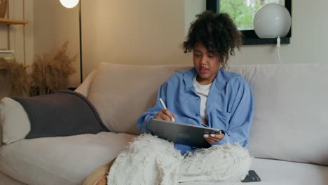 woman drawing on tablet at home
