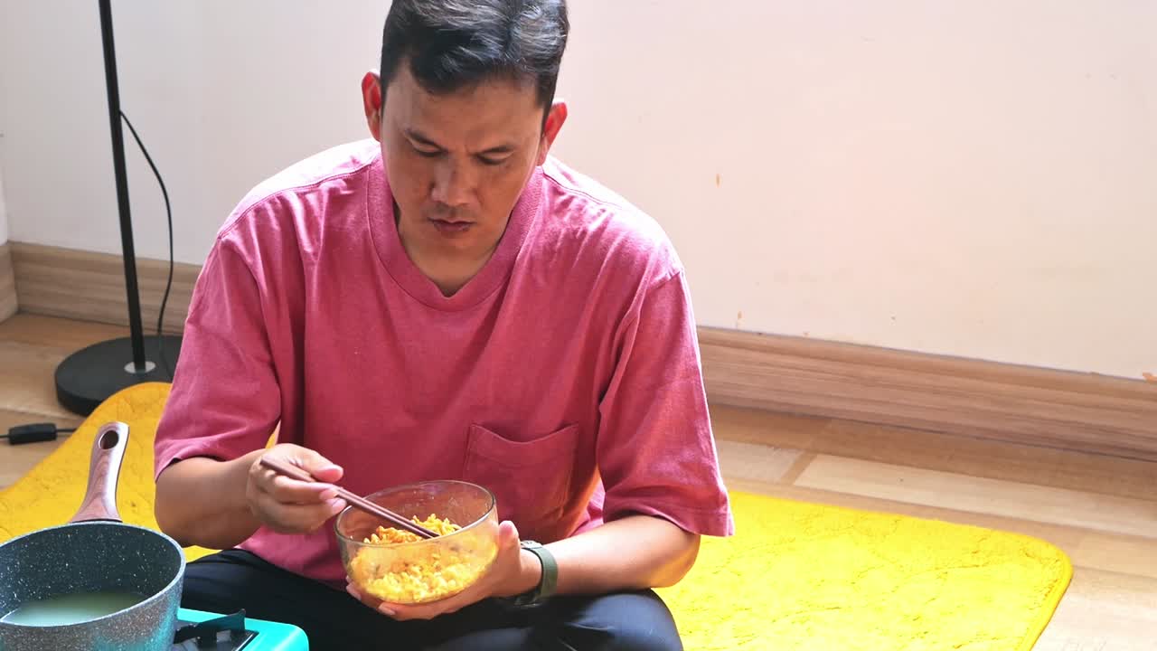 Mature Asian man is too spiciness while eating noodles