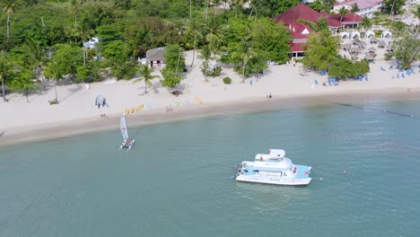 Barco-Catamarán-Anclado-Cerca-De-La-Playa-De-Arena-Blanca-En-Verano-En-El-Hotel-Bahia-Principe-Grand-La-Romana,-República-Dominicana