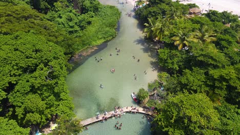 rio que deságua em uma praia, los patos, barahona, república dominicana, vista incrível com águas claras e local e ambiente turístico deslumbrante