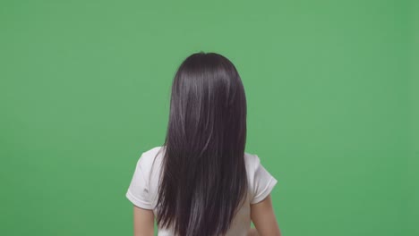 woman with long black hair, back view, white shirt against green screen