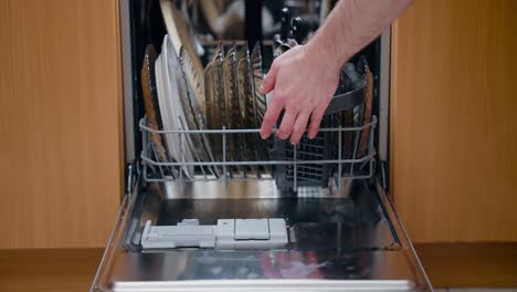 Man-Hand-Loading-Dishes-Into-Dishwasher-And-Closing-It