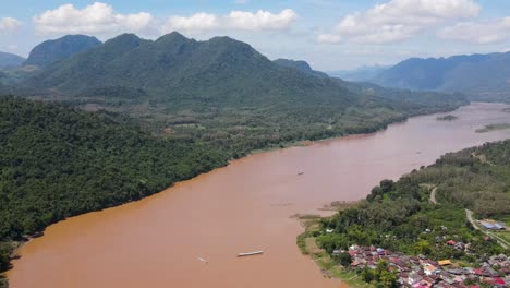 Aerial-Establishing-Shot-Of-Brown-Coloured-Mekong-River-In-Luang-prabang-Surrounded-With-Forest-Landscape