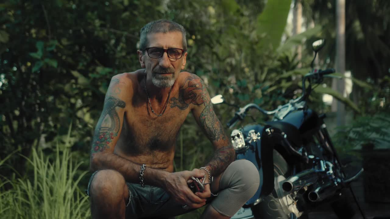 Senior biker in a tropical garden