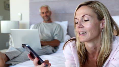 Woman-hanging-up-the-phone-and-talking-to-her-husband