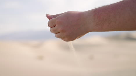 hand grabbing sand on sand dunes in death valley national park