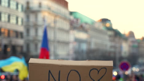 raising a protest sign against war overhead at a demonstration, prague, czechia