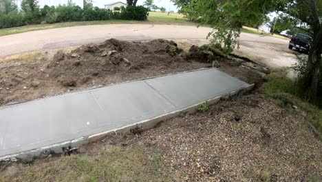 newly paved concert sidewalk outside a home in a small town on a sunny day