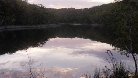 Reflejo-De-Los-árboles-Y-El-Cielo-Nublado-En-Las-Tranquilas-Aguas-Del-Lago-En-El-Parque-Nacional-Naree-Budjong-Djara,-Isla-Del-Norte-De-Stradbroke,-Queensland,-Australia---Tiro-Ancho