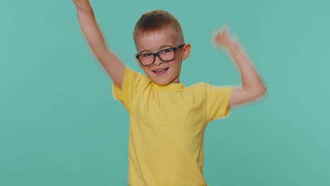 encantado encantado niño pequeño niño mostrando el gesto del rock and roll bailando regocijándose en el éxito