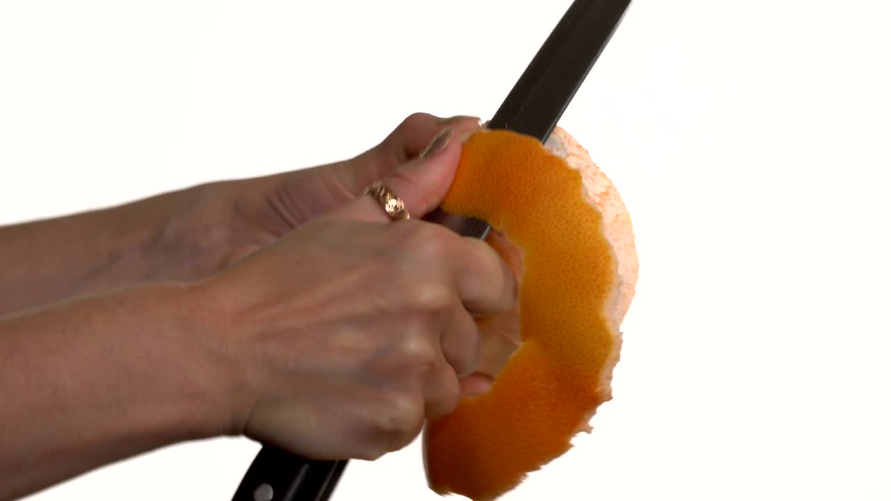 la chica corta un cuchillo para pelar el pomelo.