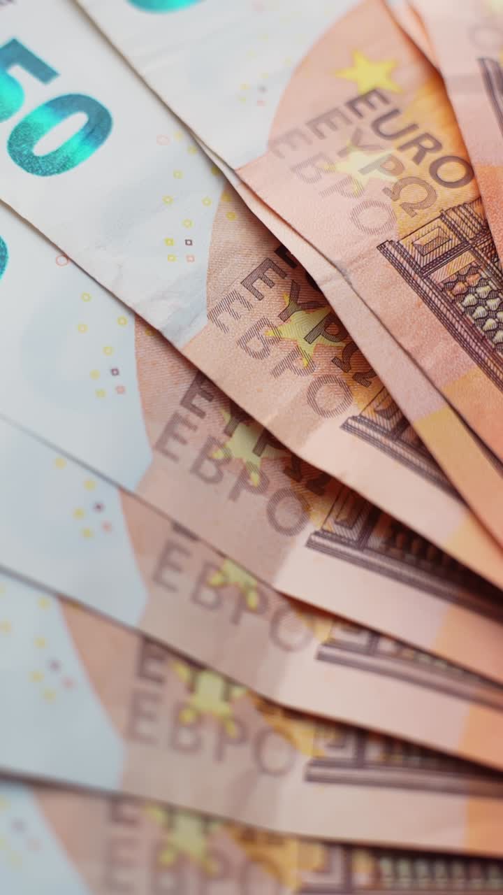 Vertikale Nahaufnahme von 50-Euro-Banknoten auf sauberem grauem Hintergrund mit Platz für Text und geringer Schärfentiefe, perfekt für Finanz-, Inflations-, Spar-, Bank- und Zahlungskonzepte