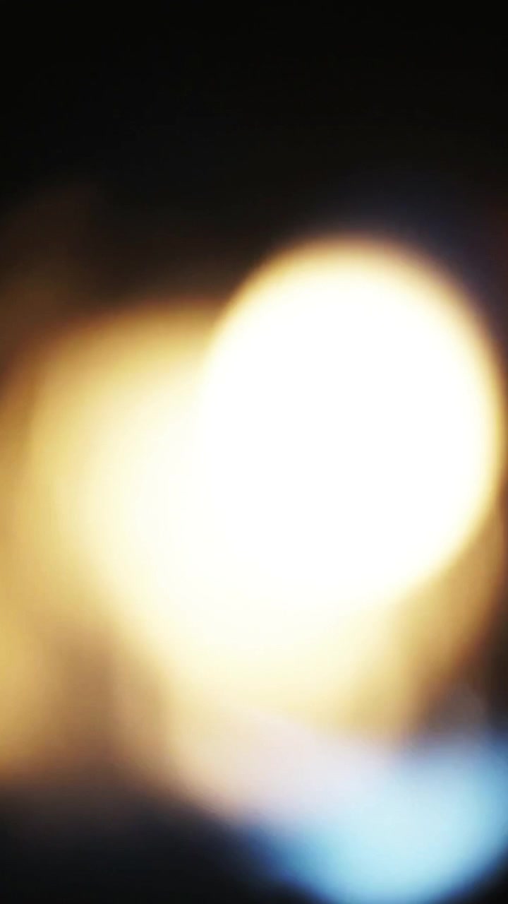 Perdite di luce astratte ed effetti bokeh su sfondo scuro.