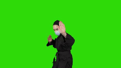 고립된 녹색 배경에 검은색 의상을 입은 닌자 여성의 촬영