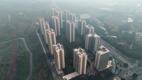 drone view of residential high-rise buildings in the outskirts of chongqing, china, surrounded by haze and greenery. capturing urban development and air pollution.