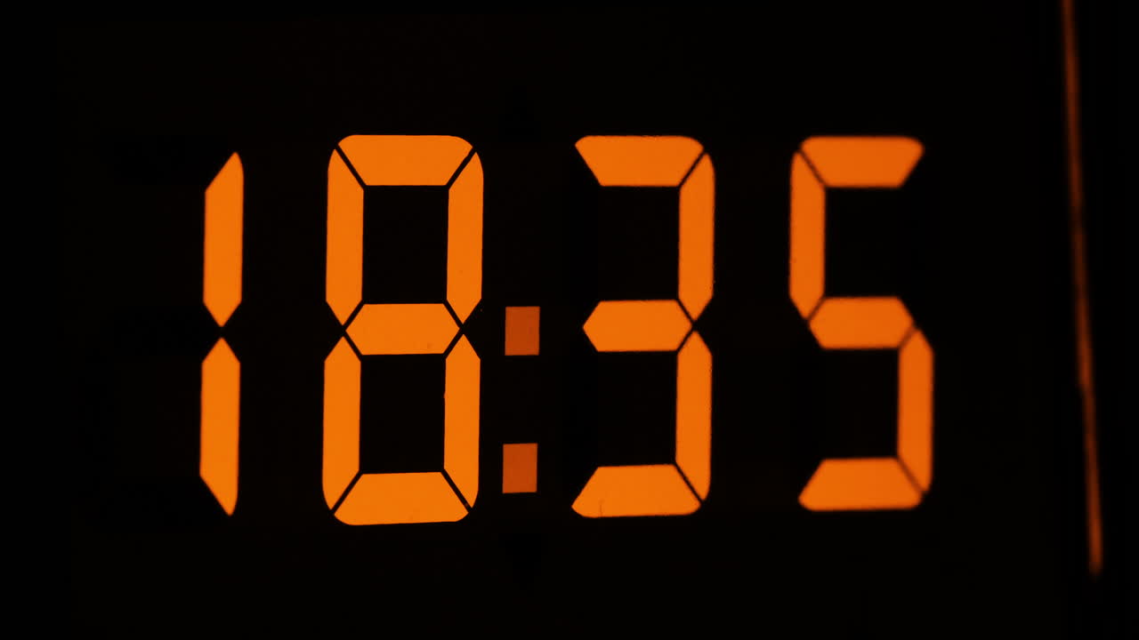 Orange display digital clock with hours flying by
