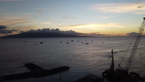 sunset over the ocean with boats and island
