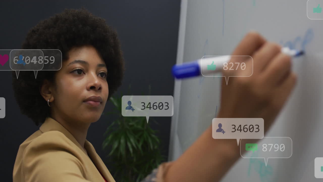Animation of icons and numbers over african american businesswoman writing in office